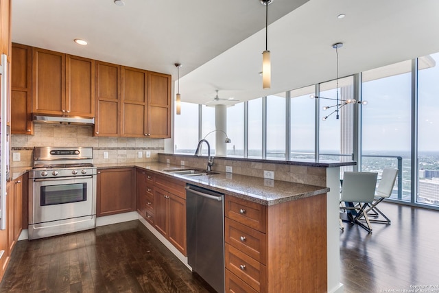 kitchen with appliances with stainless steel finishes, sink, pendant lighting, and kitchen peninsula