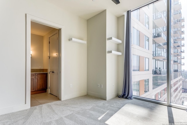 unfurnished bedroom featuring light colored carpet and ensuite bath