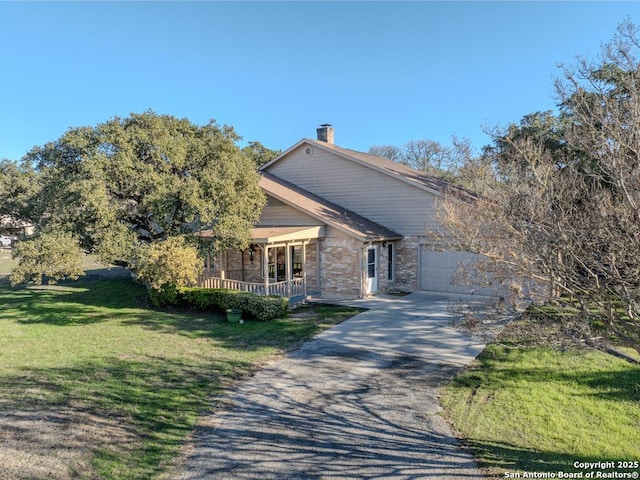 view of front of house featuring a front yard, a garage, and a porch