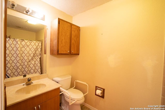 bathroom with toilet, a textured ceiling, and vanity