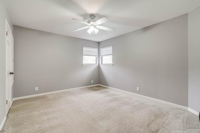 spare room with ceiling fan and light carpet