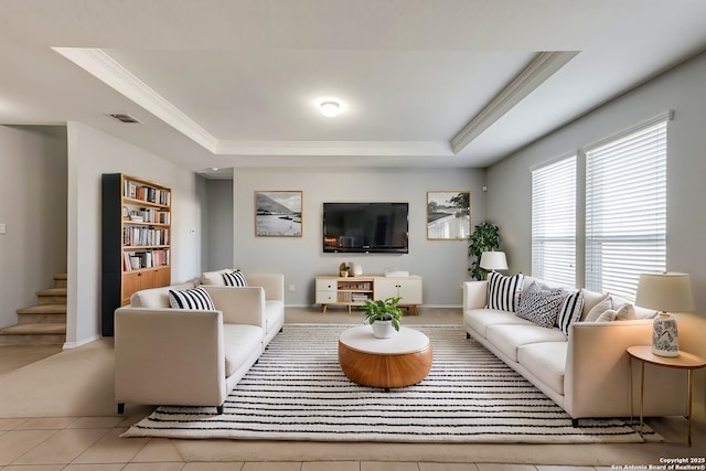 tiled living room featuring a raised ceiling and ornamental molding