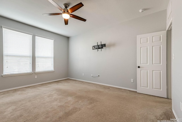 spare room with ceiling fan and light colored carpet