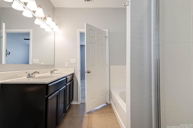 bathroom featuring tile patterned flooring, vanity, and a tub to relax in