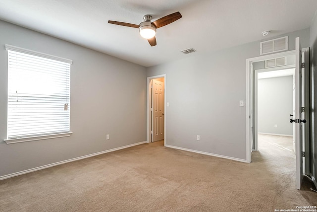 spare room featuring ceiling fan and light carpet