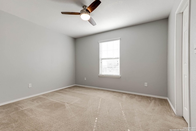 carpeted spare room with ceiling fan