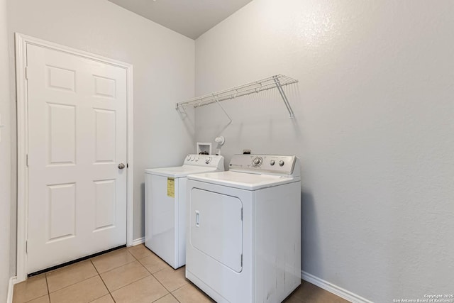 laundry area with washing machine and dryer and light tile patterned flooring