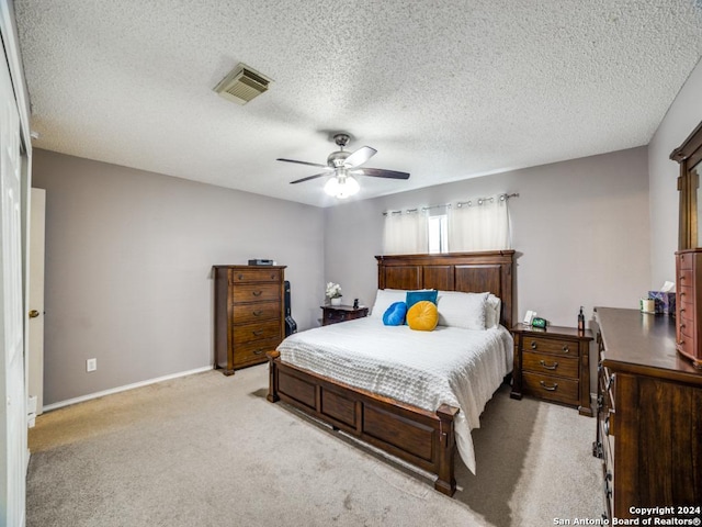 carpeted bedroom featuring ceiling fan and a textured ceiling