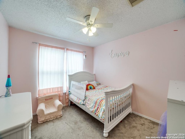 bedroom featuring ceiling fan, light carpet, and a textured ceiling