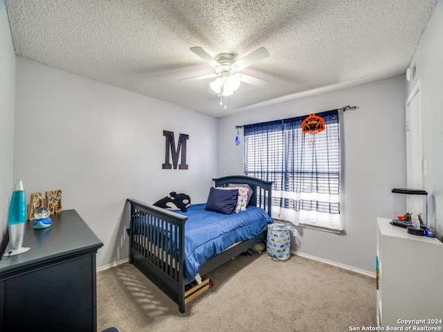 carpeted bedroom with ceiling fan and a textured ceiling