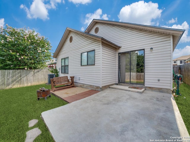 back of property with a lawn, central air condition unit, and a patio