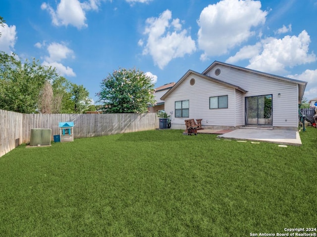 rear view of house featuring a yard, cooling unit, and a patio