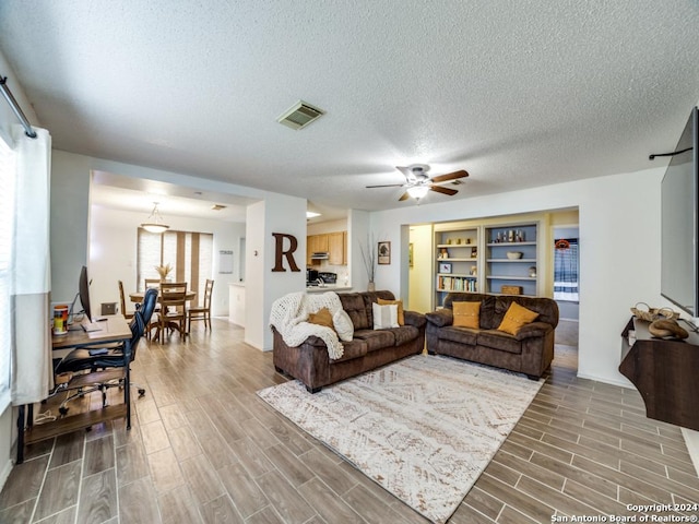 living room featuring a textured ceiling and ceiling fan