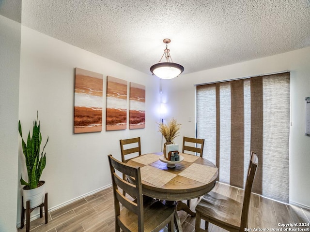 dining space featuring hardwood / wood-style floors and a textured ceiling