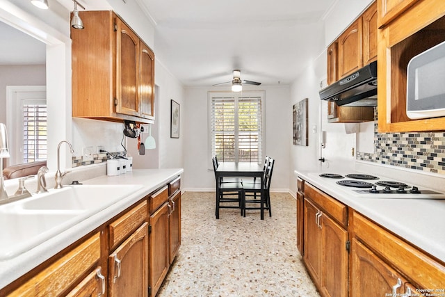 kitchen featuring backsplash, ceiling fan, crown molding, sink, and white electric stovetop