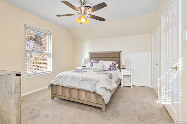 carpeted bedroom with ceiling fan and vaulted ceiling