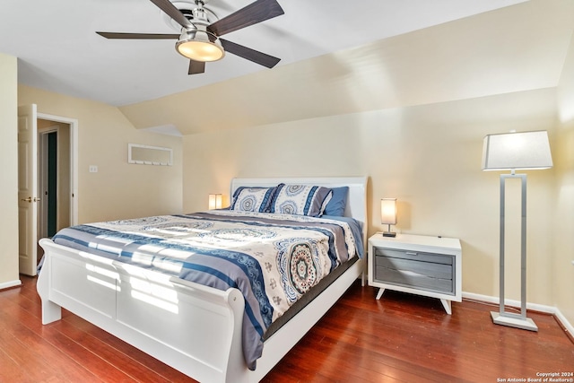 bedroom with ceiling fan, dark wood-type flooring, and vaulted ceiling