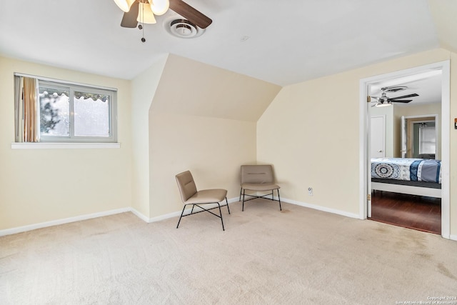 sitting room featuring light colored carpet, vaulted ceiling, and ceiling fan