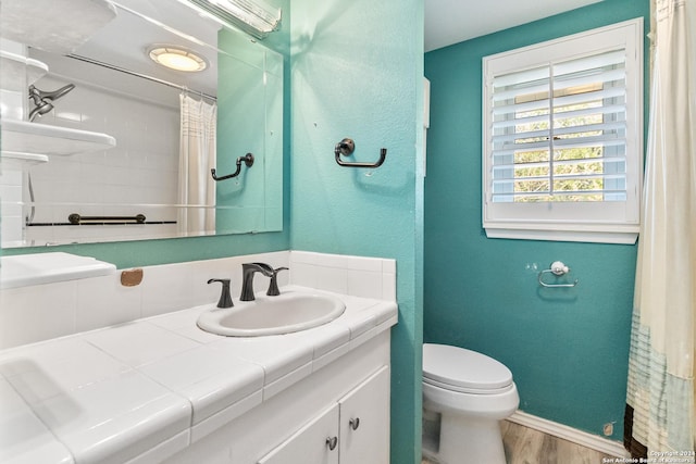 bathroom featuring hardwood / wood-style floors, vanity, curtained shower, and toilet