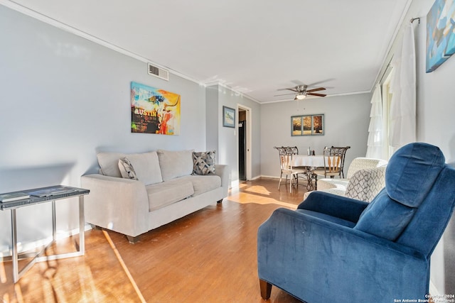 living room with crown molding, hardwood / wood-style floors, and ceiling fan