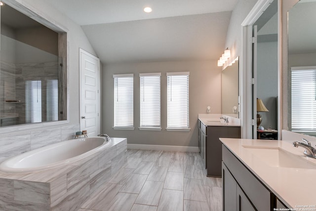 bathroom with vanity, shower with separate bathtub, and vaulted ceiling