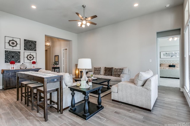 living room featuring ceiling fan with notable chandelier