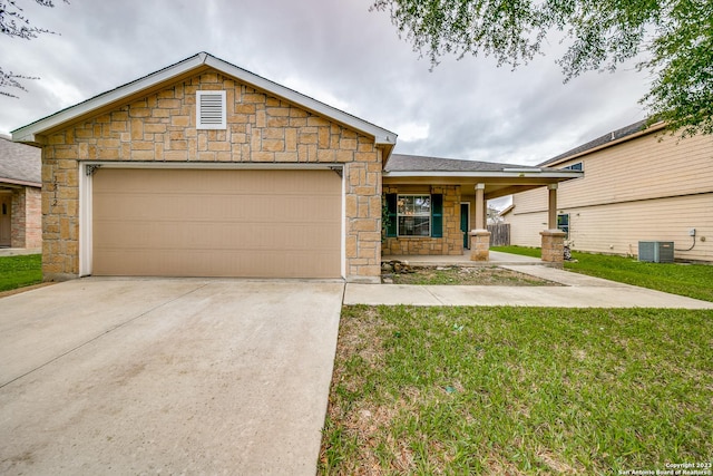 single story home with covered porch, a garage, and a front lawn