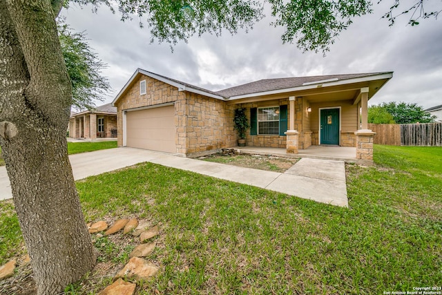 single story home featuring covered porch, a garage, and a front yard