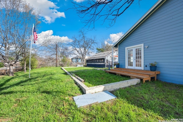 view of yard featuring a wooden deck and french doors