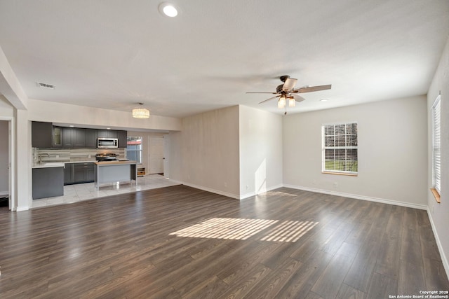 unfurnished living room featuring dark hardwood / wood-style floors and ceiling fan