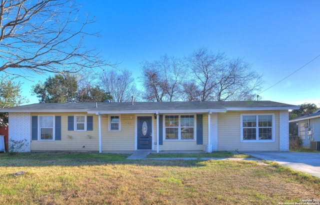 single story home featuring cooling unit and a front yard