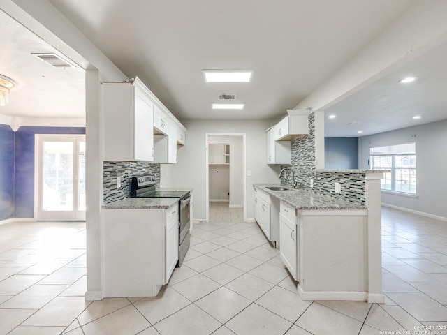 kitchen featuring tasteful backsplash, white cabinets, light stone counters, and stainless steel range with electric cooktop