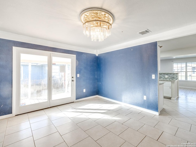 tiled spare room with ornamental molding and an inviting chandelier