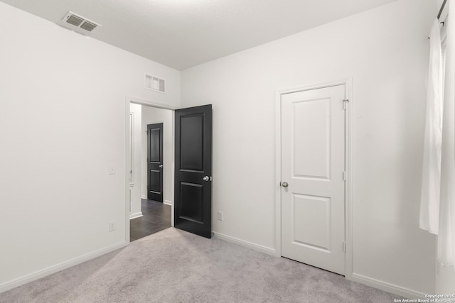 unfurnished bedroom featuring light carpet