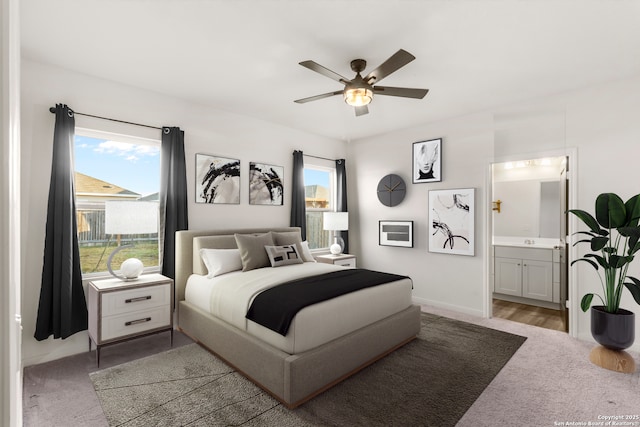 bedroom with ensuite bathroom, ceiling fan, and light colored carpet