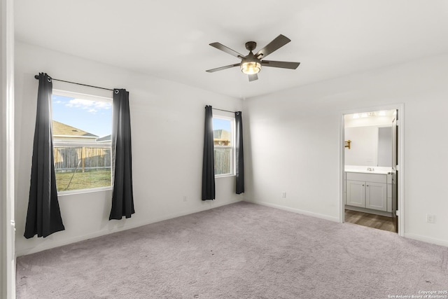 unfurnished bedroom featuring light carpet, ensuite bath, and ceiling fan