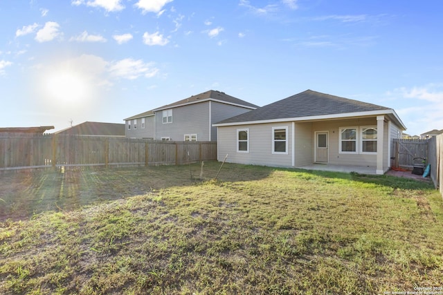 rear view of house featuring a patio area and a lawn