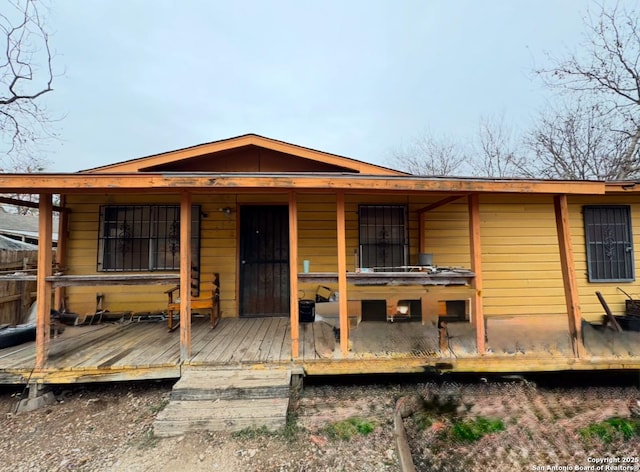 rear view of property featuring a wooden deck