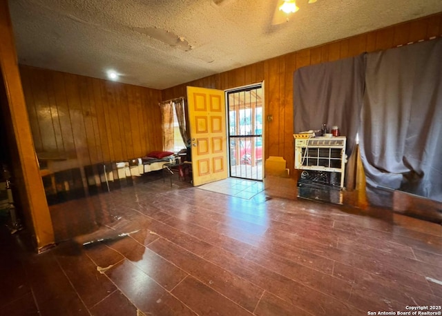 interior space featuring a textured ceiling and wooden walls