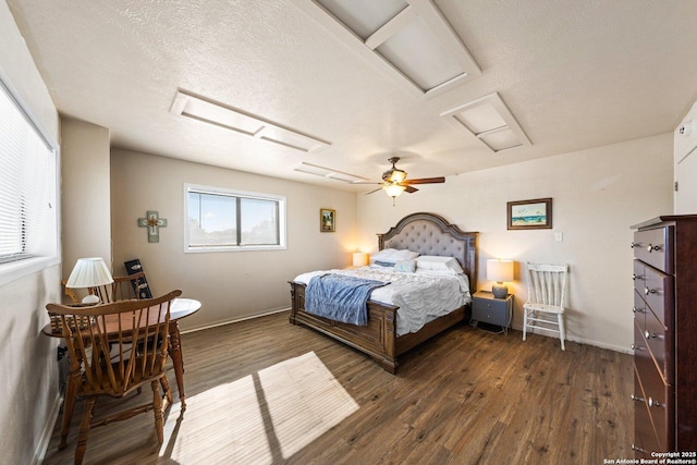 bedroom with ceiling fan, dark hardwood / wood-style flooring, and a textured ceiling