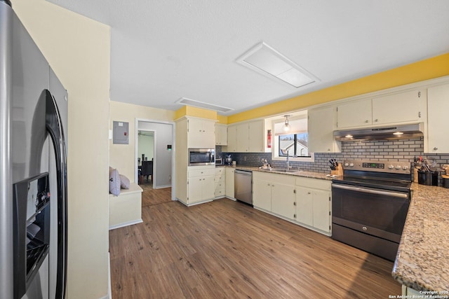 kitchen featuring backsplash, stainless steel appliances, sink, cream cabinets, and light hardwood / wood-style floors