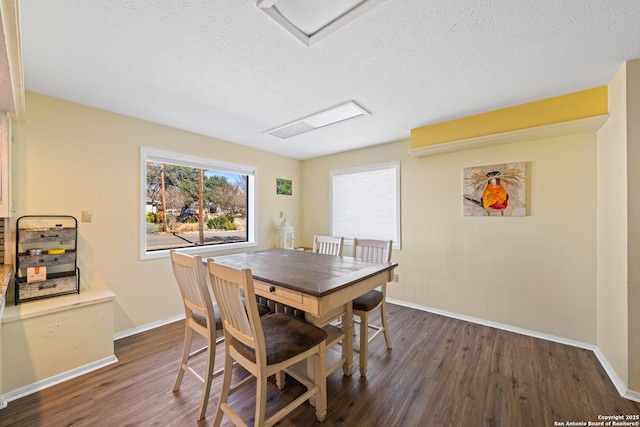 dining space with a textured ceiling and dark wood-type flooring