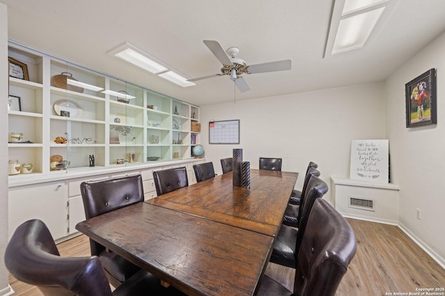 dining room with ceiling fan and light hardwood / wood-style flooring