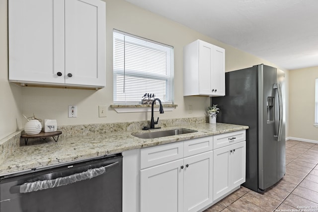 kitchen with white cabinets, sink, light tile patterned floors, light stone counters, and stainless steel appliances