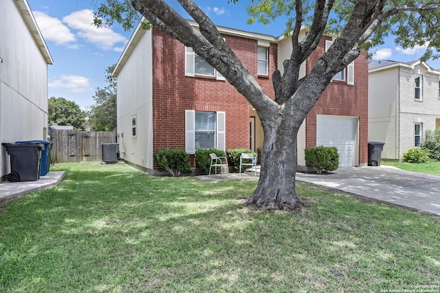 multi unit property featuring cooling unit, a front yard, and a garage