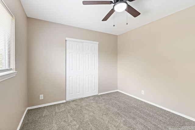 unfurnished bedroom with carpet, ceiling fan, and a closet