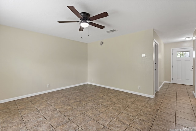 empty room with ceiling fan and light tile patterned flooring