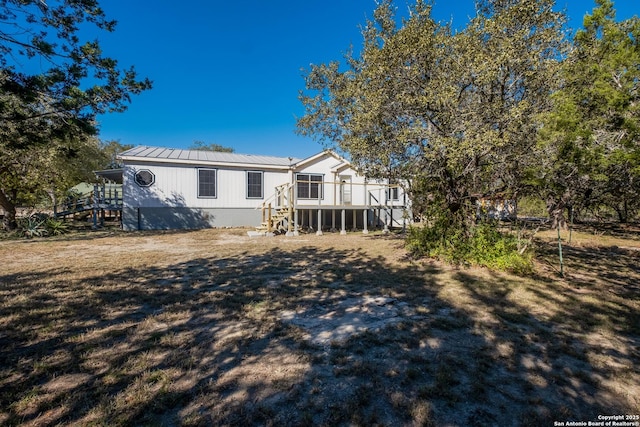 rear view of house with a lawn and a wooden deck