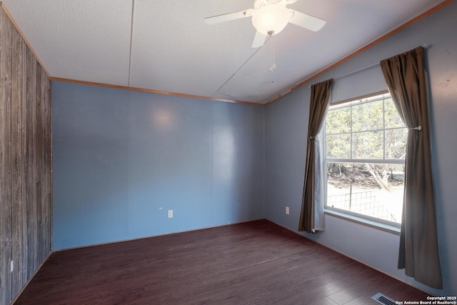 unfurnished room with ornamental molding, a textured ceiling, vaulted ceiling, ceiling fan, and dark wood-type flooring