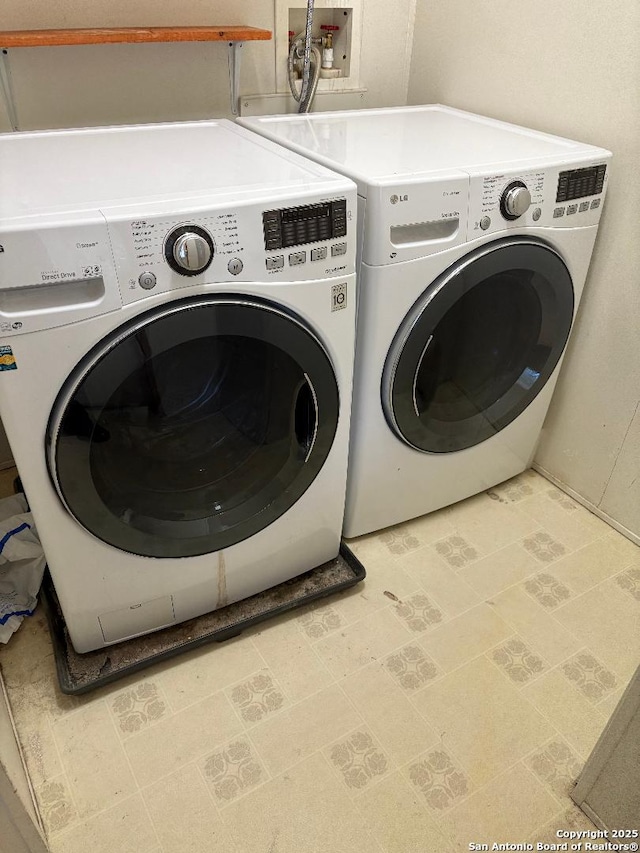 clothes washing area with washing machine and dryer